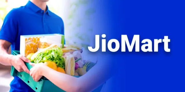 JioMart Quick Commerce delivery executive on a scooter, wearing a JioMart branded uniform and carrying a delivery box, against the backdrop of a busy Indian city street.