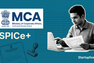 A founder reviews company registration in India documents on the MCA SPICe+ portal with incorporation papers spread across a desk.